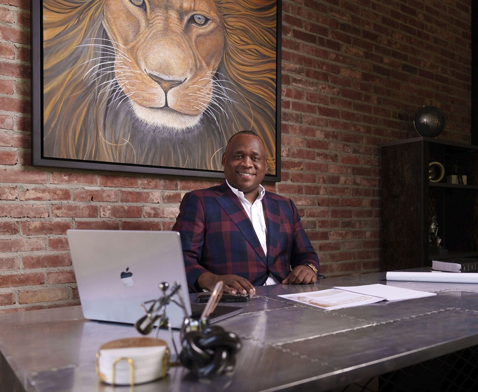 Antwann Richardson at his desk beneath a lion painting