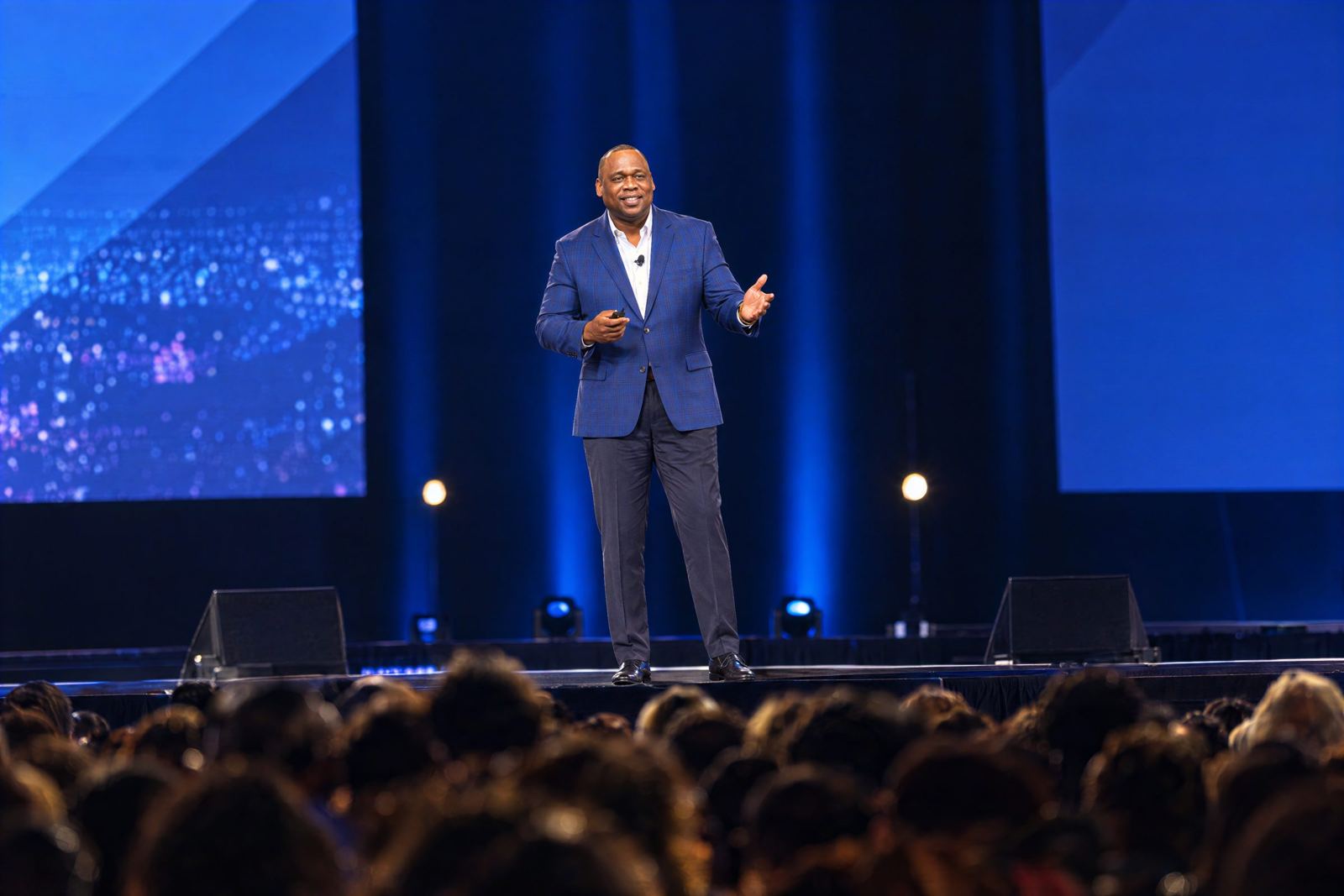 Antwann Richardson speaking on stage to a full arena